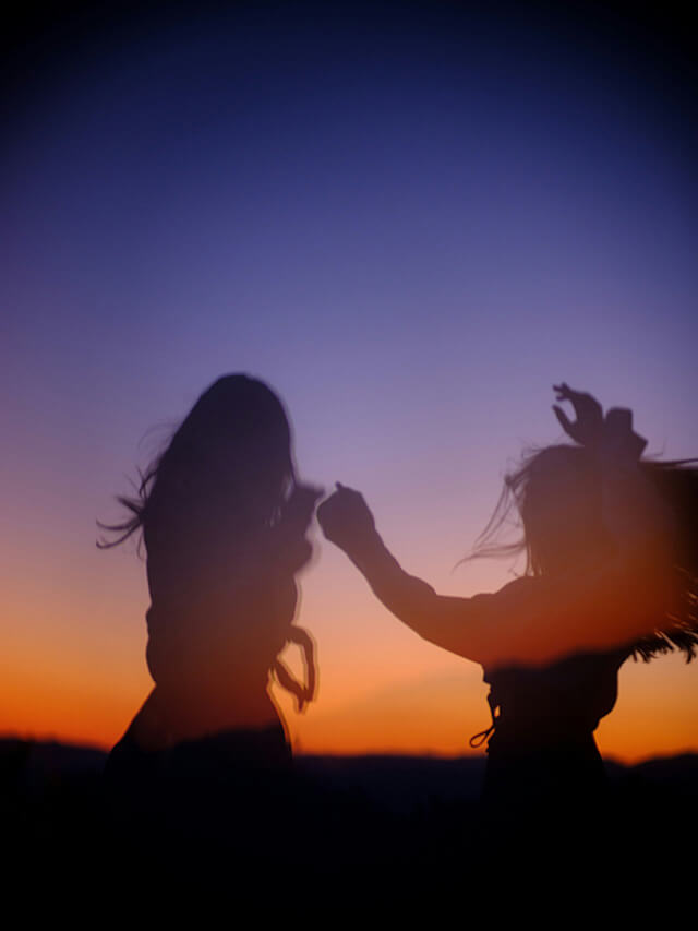 silhouette of two girls dancing during sunset